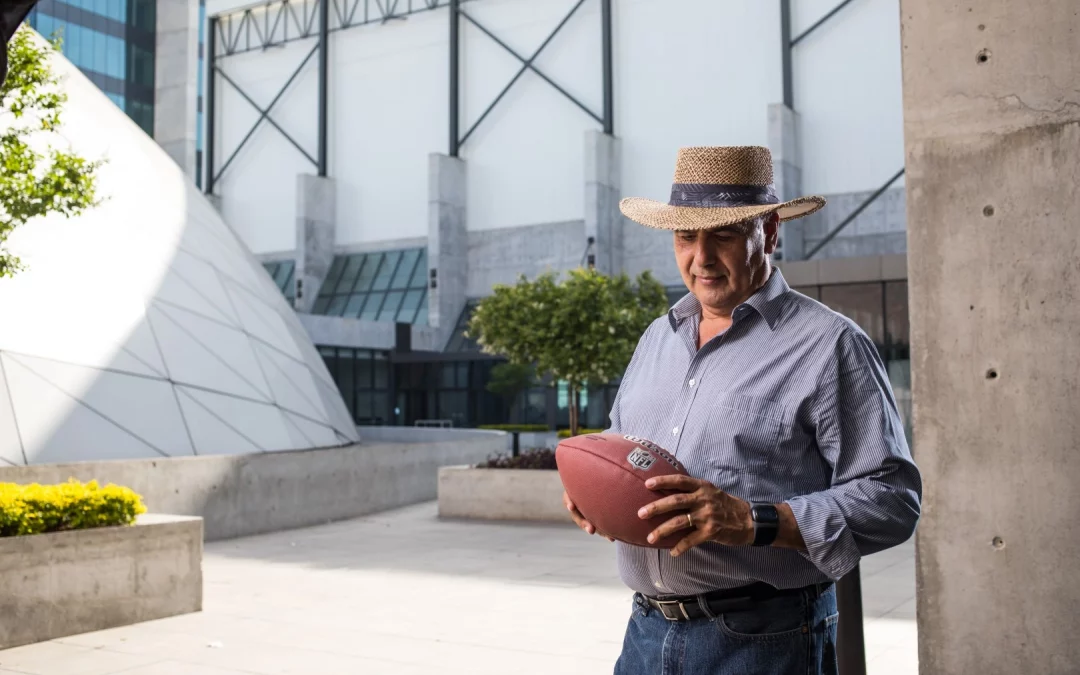 Coach motivacional; coach delante de unas instalaciones con un balón en las manos